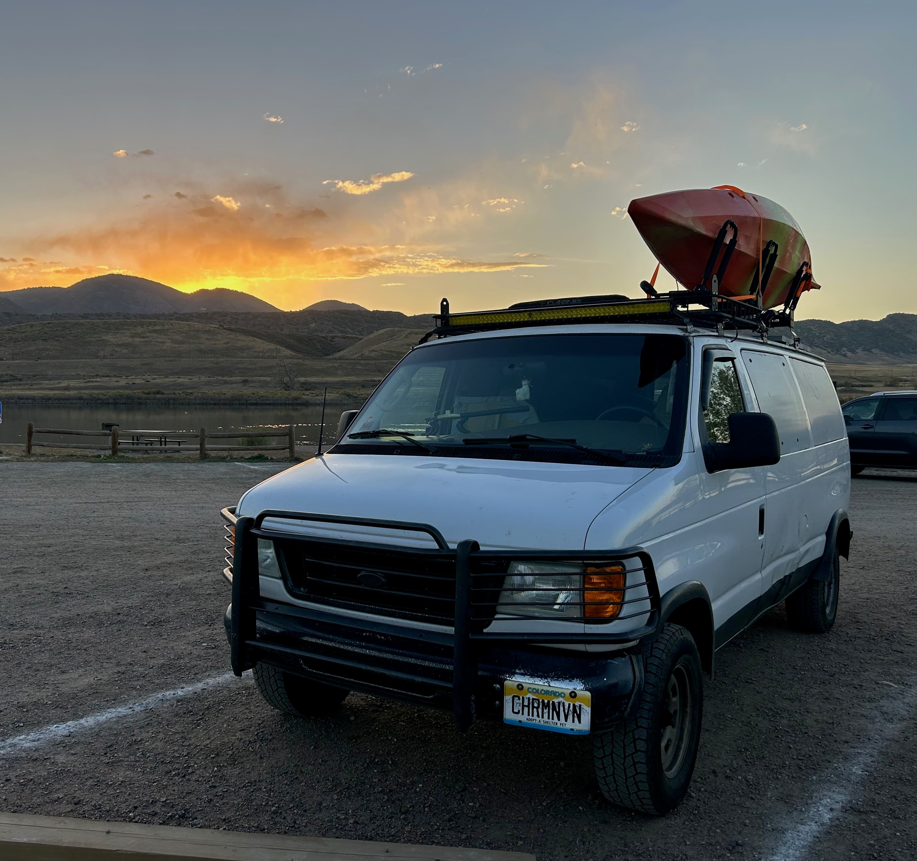 a camper van in front of a mountain at sunset